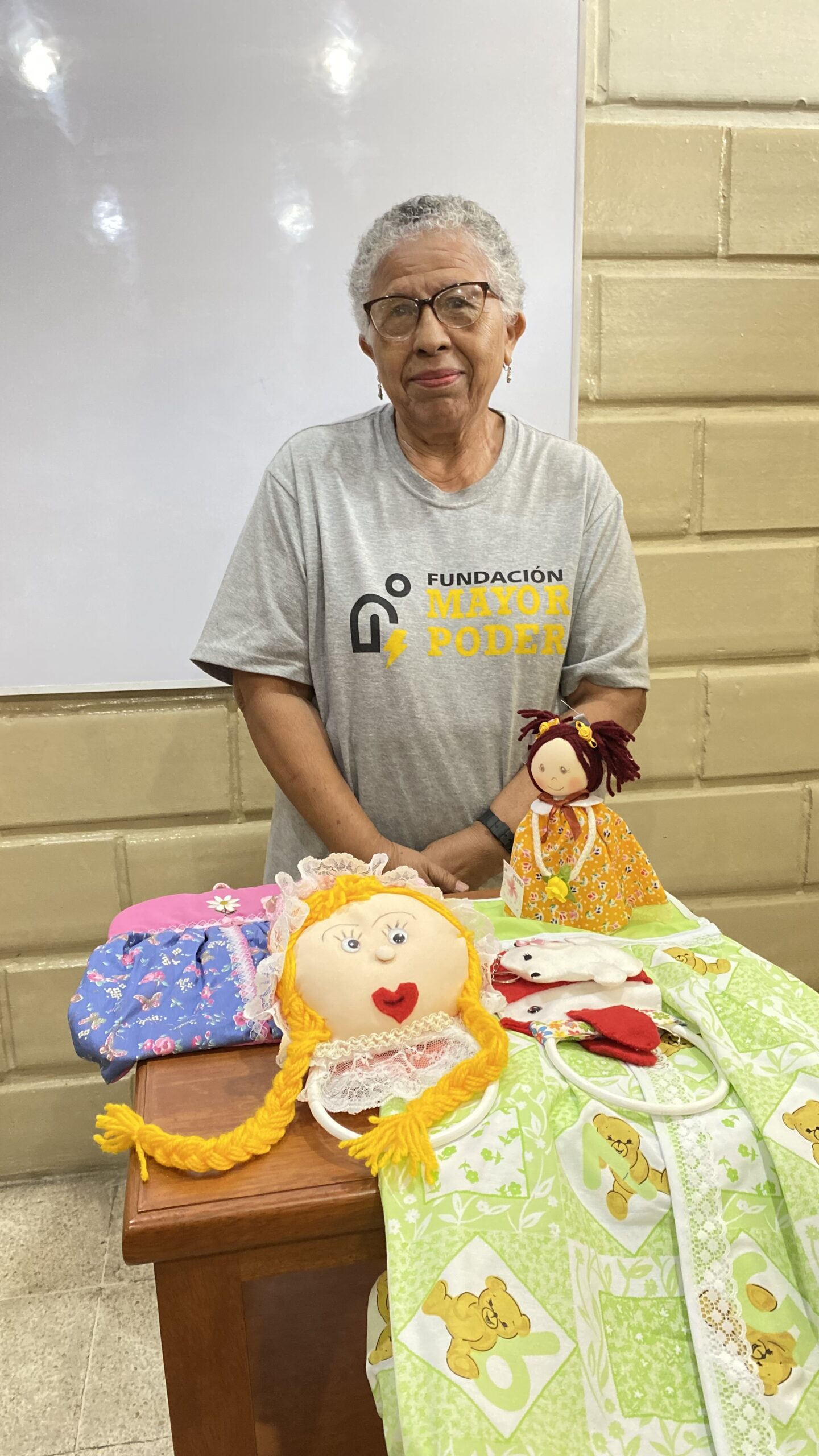 Beneficiaria mostrando una muñeca artesanal