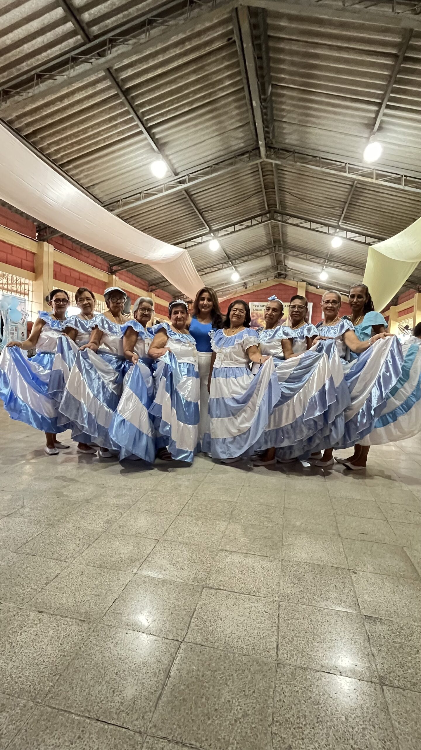 Grupo de danza tradicional con vestidos azules y blancos